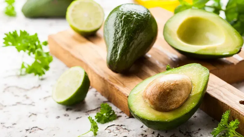 Hình ảnh minh họa các loại trái cây chứa vitamin E như bơ, kiwi và xoài. 