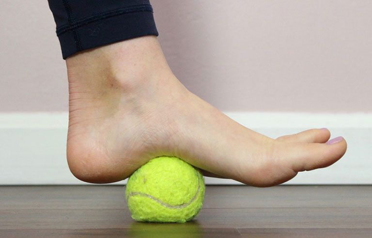 Bài tập lăn lòng bàn chân với bóng giúp kéo giãn dải cân gan chân và tăng cường kích thích cảm giác bản thể cho trẻ