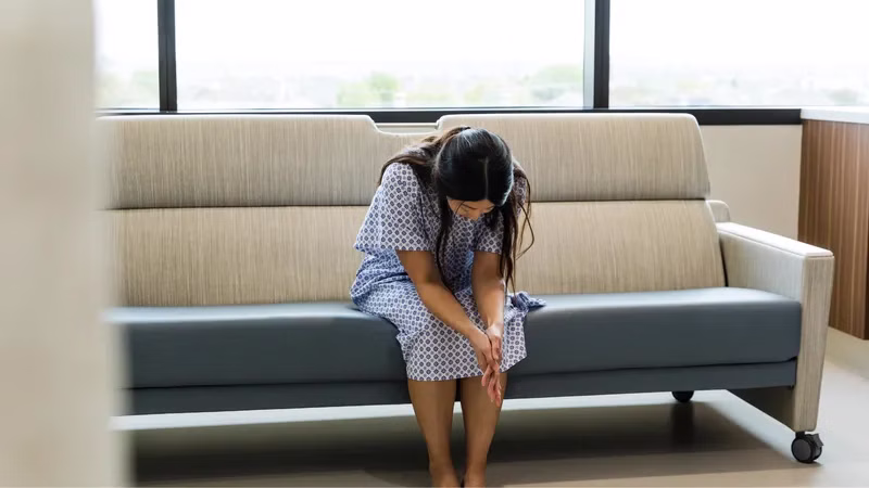 Hình minh họa người phụ nữ đang ngồi suy tư thể hiện sự lo âu về sức khỏe