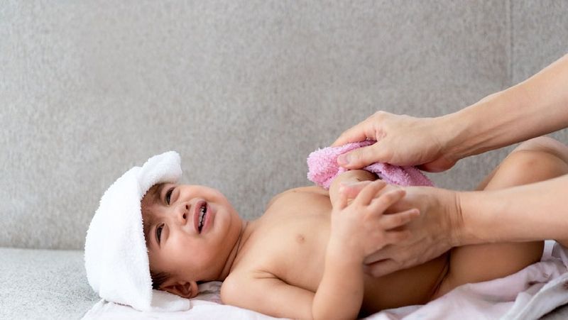 Quy trình sơ cứu lau mát bằng nước ấm tại các vùng nách, bẹn giúp hạ thân nhiệt cho trẻ sơ sinh một cách an toàn